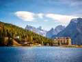 Paesaggio incantevole dei laghi del Veneto e Trentino, con un lago blu, montagne imponenti e un hotel storico.