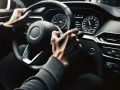 Mani sul volante, pronto a guidare con le nuove regole foglio rosa. Il cruscotto illuminato mostra la strada.