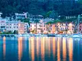Il lungolago di Toscolano Maderno cosa vedere: hotel storici, palazzi colorati e barche a vela ormeggiate, con riflessi dorati sull'acqua.