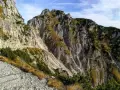 Sentiero roccioso in montagna, parte della strada degli eroi anello, con vegetazione sparsa e cielo azzurro.