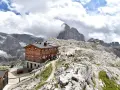 Rifugio Pian di Cengia, un accogliente rifugio alpino tra le maestose Dolomiti, con escursionisti che riposano.