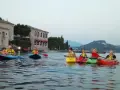 Persone in kayak sul lago verde, con un antico edificio sullo sfondo, vicino a San Vigilio di Marebbe.