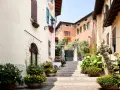 Un vicolo fiorito nel gardone riviera centro storico, con scale di pietra, case colorate e piante rigogliose.