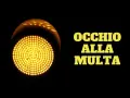 Semaforo giallo acceso, con la scritta "OCCHIO ALLA MULTA". Attenzione a non passare con il giallo, potresti ricevere una multa!