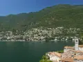 Un'ottima idea per sapere dove andare in montagna in Lombardia in giornata: un borgo pittoresco sul lago, con case colorate e montagne verdi sullo sfondo.