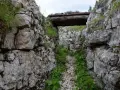 Trincea scavata nella roccia sul Monte Ortigara, con un tetto di tronchi. Per sapere come arrivare, cerca sentieri storici.