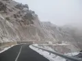 Strada innevata al passo del Faiallo, con rocce e vegetazione ghiacciate.