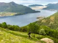 Un atleta corre su un sentiero erboso con vista sul Lago di Como, un'emozionante randonnée.
