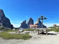 Croce e rifugio al cospetto delle Tre Cime di Lavaredo, un luogo iconico in Val Fiscalina.