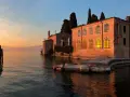 Punta San Vigilio: un tramonto dorato illumina la spiaggia e l'antica villa affacciata sul lago.
