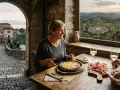 Coppia assapora delizie culinarie con vista su uno dei borghi friulani da visitare, un'esperienza indimenticabile.