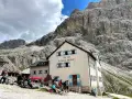 Rifugio Vajolet, punto di partenza per un percorso facile verso le Torri del Vajolet. Persone riposano sotto le imponenti rocce.