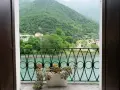Balcone fiorito con vista sul lago e montagne verdi, un angolo di pace a Cismon del Grappa.