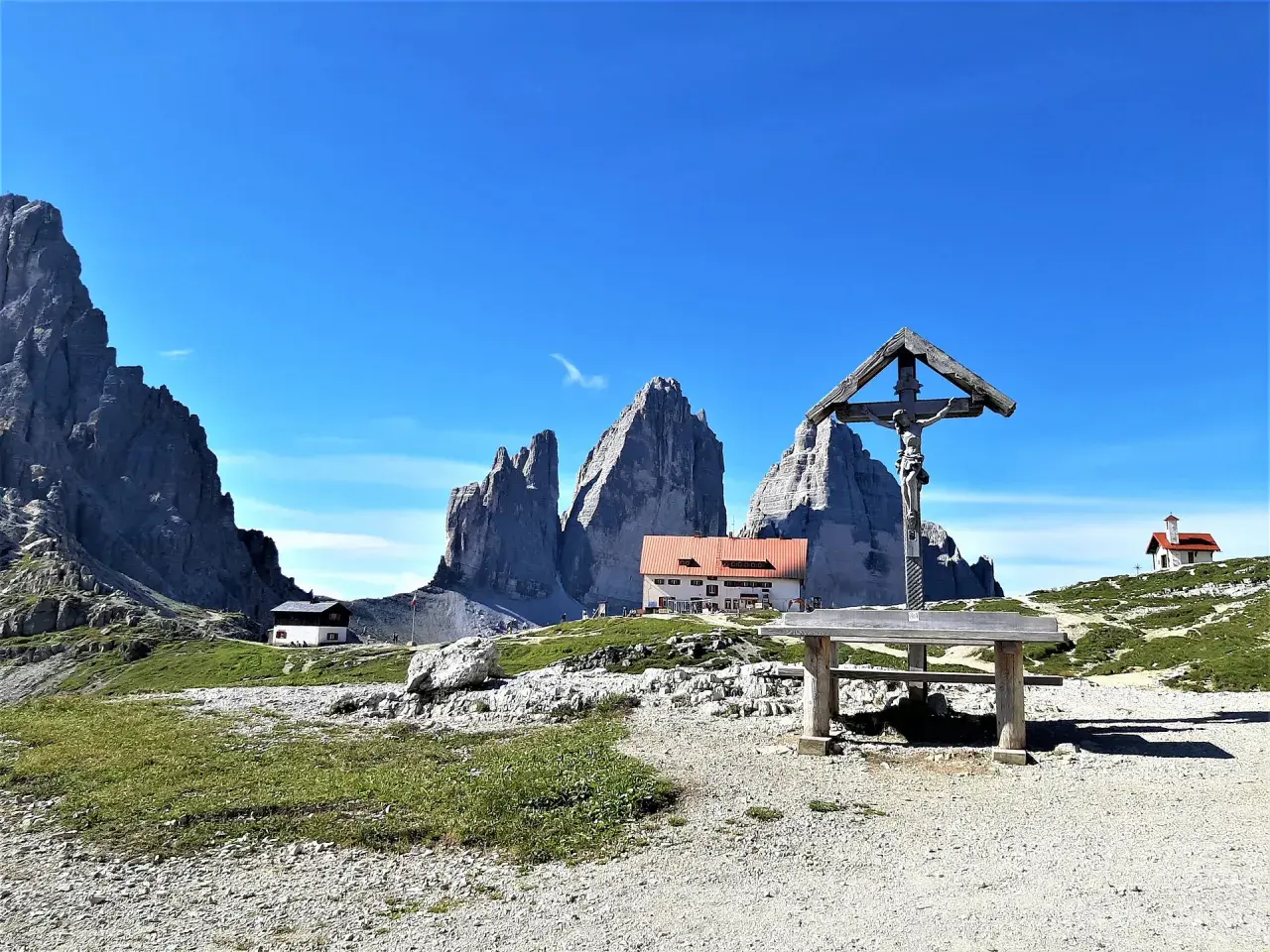Croce e rifugio al cospetto delle Tre Cime di Lavaredo, un luogo iconico in Val Fiscalina.