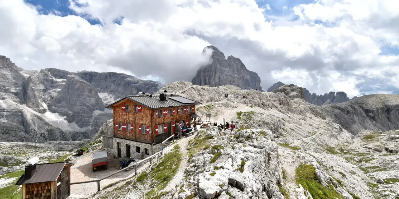 Rifugio Pian di Cengia, un accogliente rifugio alpino tra le maestose Dolomiti, con escursionisti che riposano.