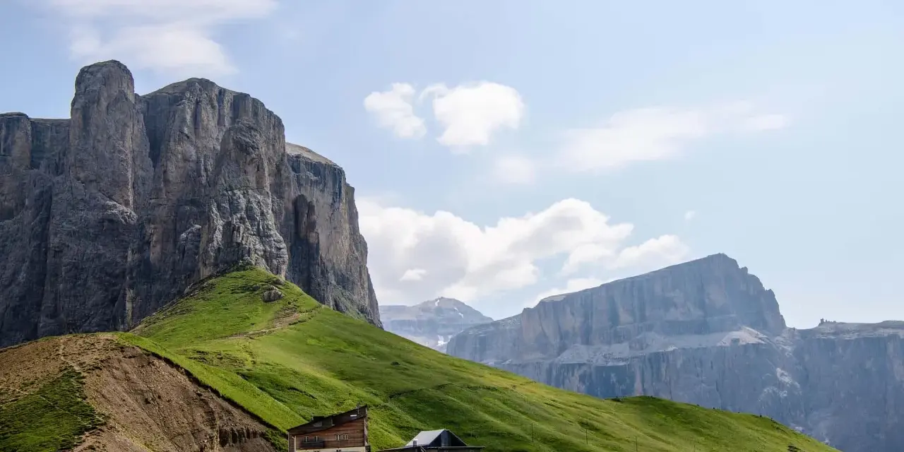 Panorami mozzafiato al Passo Sella: imponenti pareti rocciose, verdi pendii e rifugi alpini. Cosa vedere in questo paradiso dolomitico.