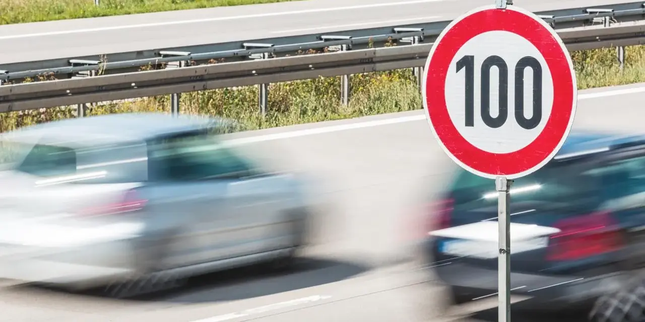 Segnale di limite di velocità 100. Auto in transito, rispettando la tolleranza limite di velocità.