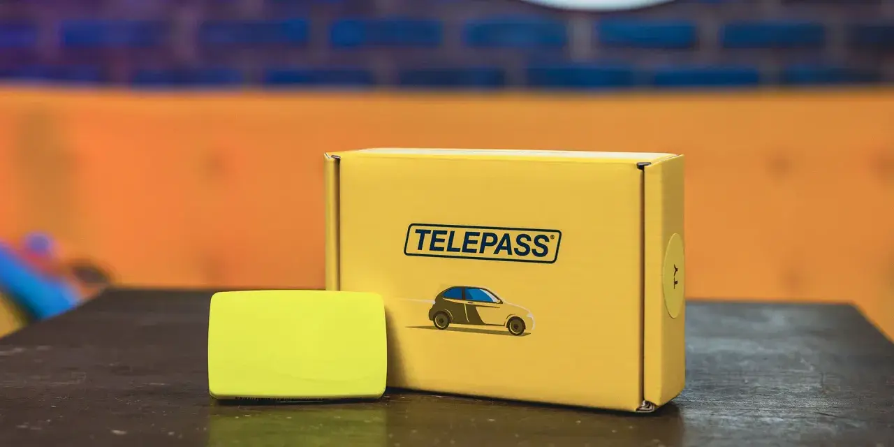 Il dispositivo Telepass e la sua confezione gialla, pronti per il tuo prossimo viaggio. Un comodo recesso telepass per viaggiare senza pensieri.