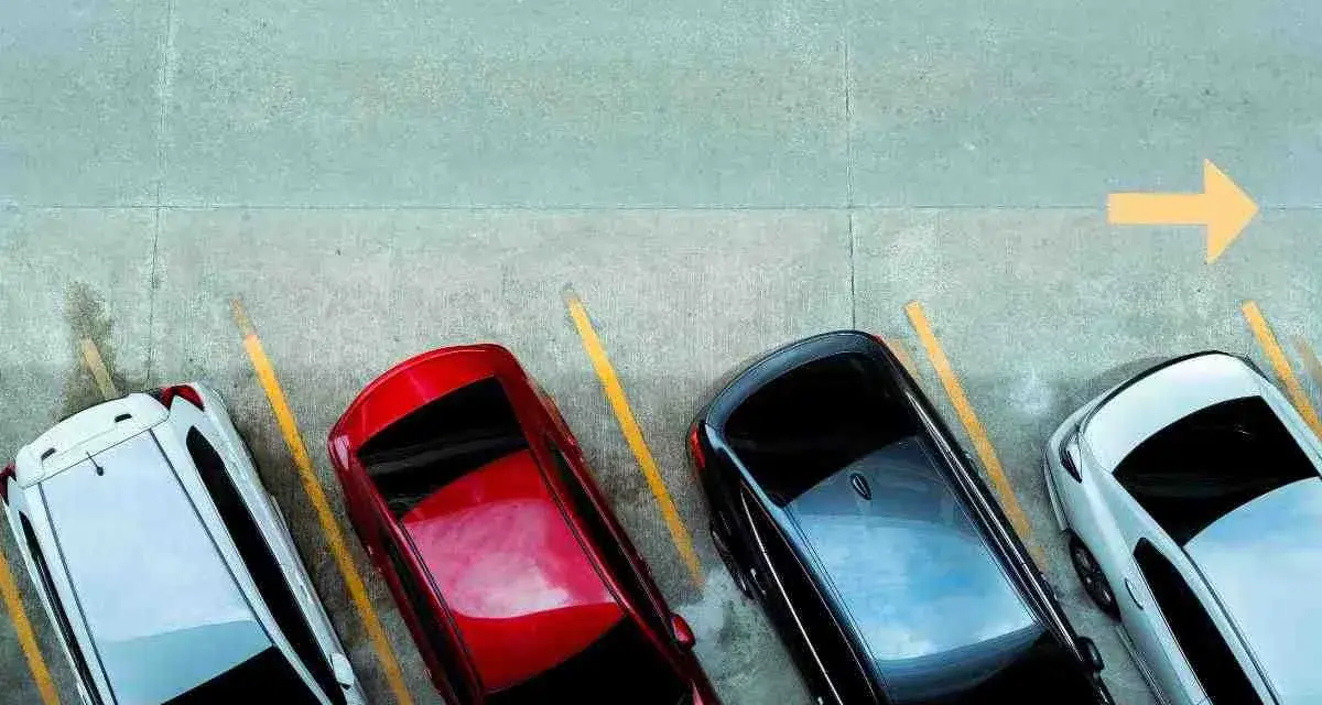 Quattro auto parcheggiate in parallelo, con freccia gialla che indica la direzione.