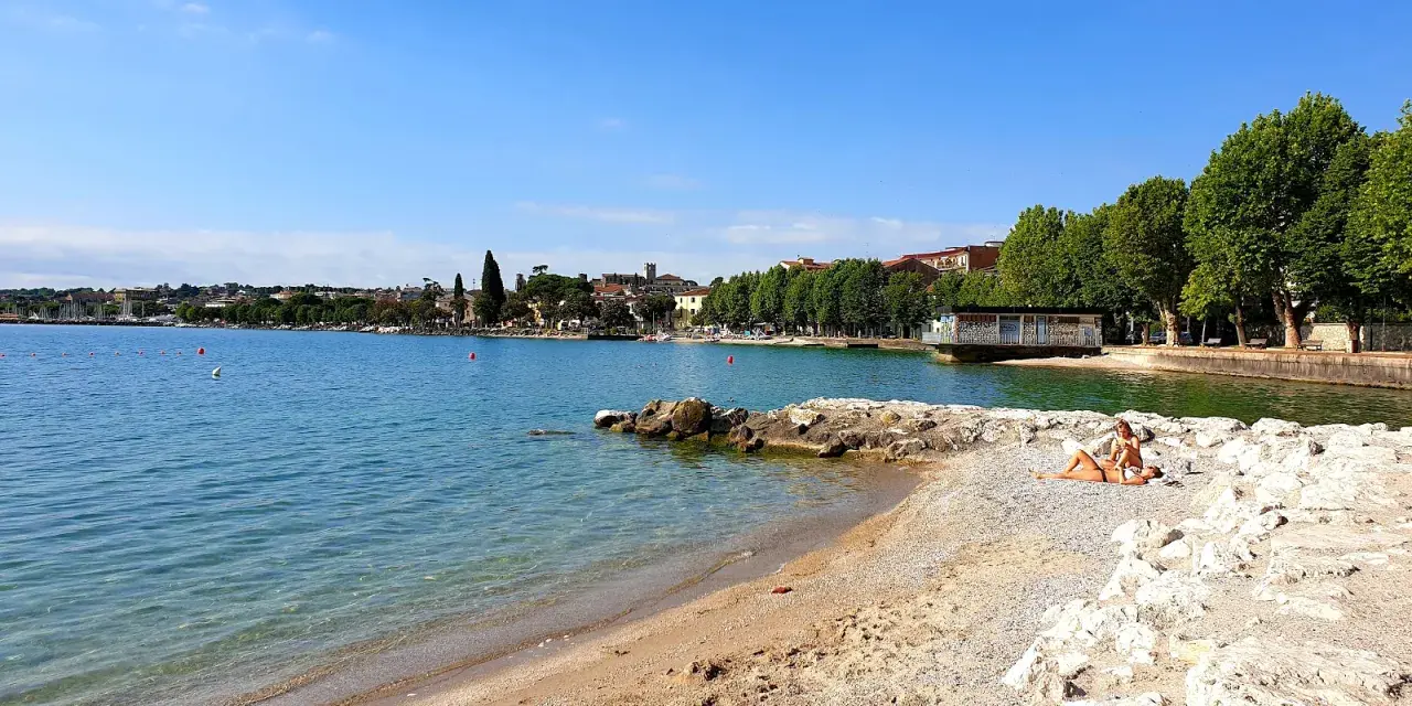Spiaggia Desenzanino con persone che prendono il sole. Informazioni sui prezzi disponibili online per godersi il lago.