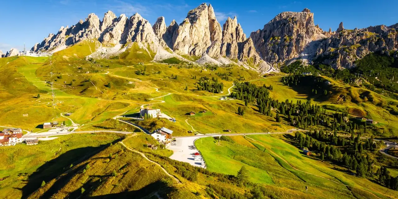 Panorami mozzafiato per un trekking 2 giorni Trentino. Sentieri serpeggianti tra prati verdi e imponenti vette dolomitiche.