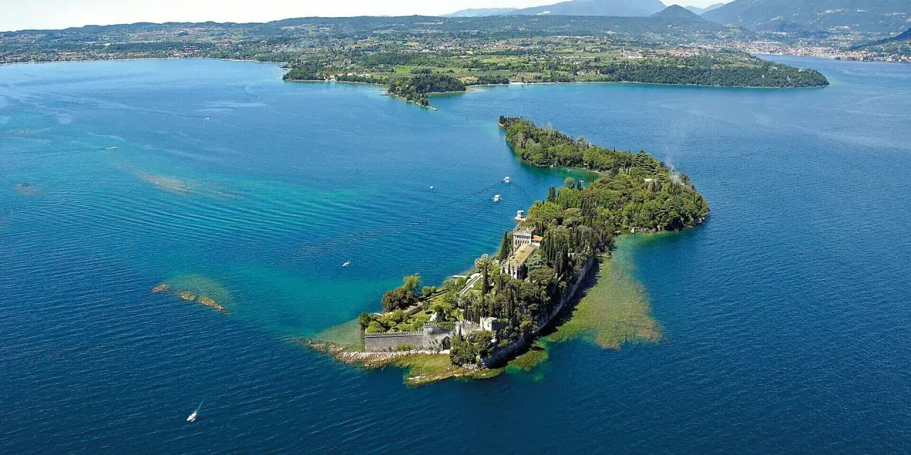 Le splendide isole del Lago di Garda, con ville storiche e vegetazione lussureggiante, emergono dalle acque turchesi.