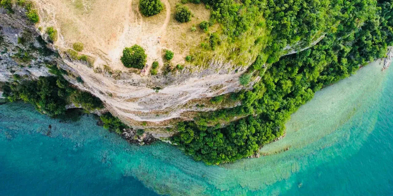 Vista aerea di Manerba del Garda: scogliere, vegetazione lussureggiante e acque cristalline del lago. Scopri cosa vedere in questo incantevole angolo del Garda.