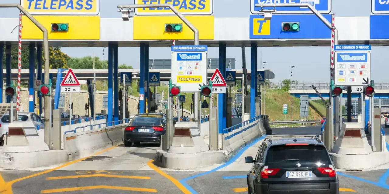 Casello autostradale con corsie Telepass e carte. Un'auto nera attende, forse per un mancato pagamento Telepass senza ricevuta.