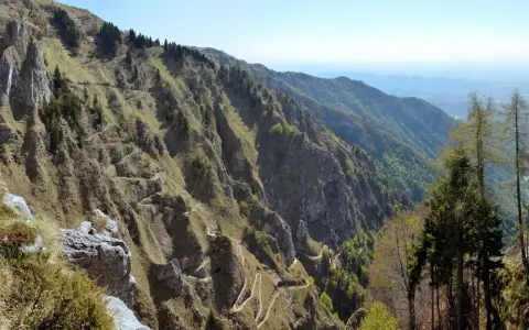 Sentiero tortuoso che si snoda sui ripidi pendii delle Prealpi Venete, ideale per escursioni panoramiche.