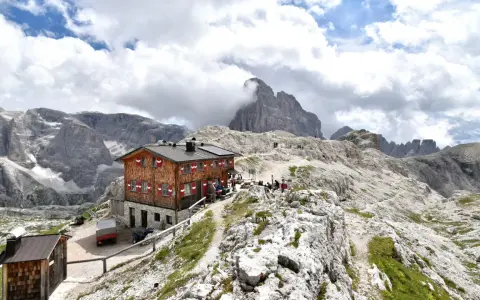Rifugio Pian di Cengia, un accogliente rifugio alpino tra le maestose Dolomiti, con escursionisti che riposano.