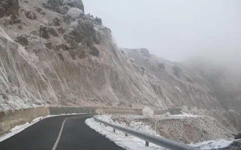 Strada innevata al passo del Faiallo, con rocce e vegetazione ghiacciate.