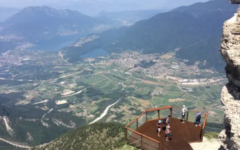 Vista panoramica dal Pizzo di Levico con un punto panoramico e persone che ammirano la valle sottostante.