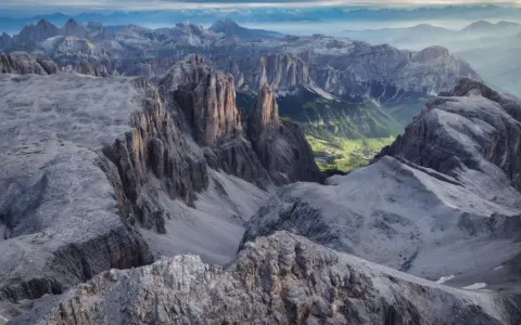Viste mozzafiato dalle cime rocciose del Piz Boè, con un verde villaggio incastonato tra le valli.