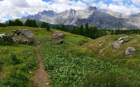 Sentiero per alpe devero trekking tra baite in pietra e montagne maestose.