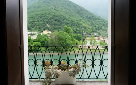 Balcone fiorito con vista sul lago e montagne verdi, un angolo di pace a Cismon del Grappa.