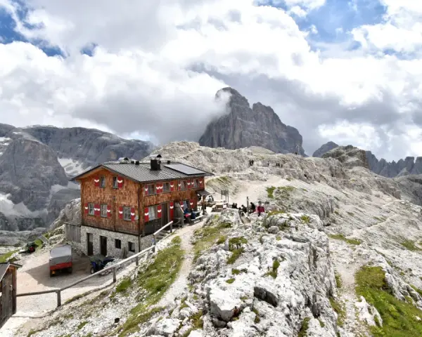 Rifugio Pian di Cengia, un accogliente rifugio alpino tra le maestose Dolomiti, con escursionisti che riposano.