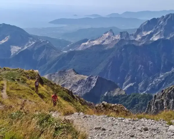 Due escursionisti affrontano la via Vandelli, un sentiero di montagna con notevole difficoltà, tra panorami mozzafiato e cave di marmo.