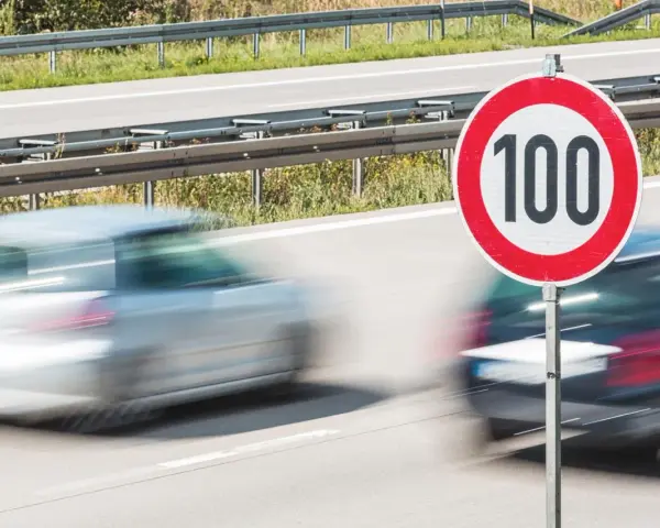 Segnale di limite di velocità 100. Auto in transito, rispettando la tolleranza limite di velocità.