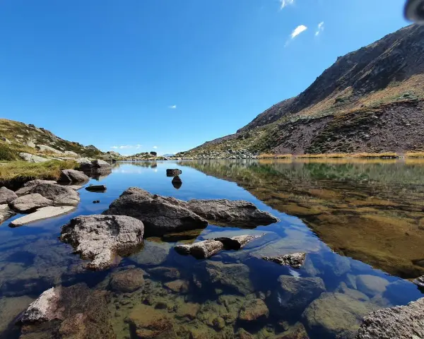 Laghi alpini cristallini vicino Vipiteno, con rocce affioranti e riflessi del cielo azzurro e delle montagne.