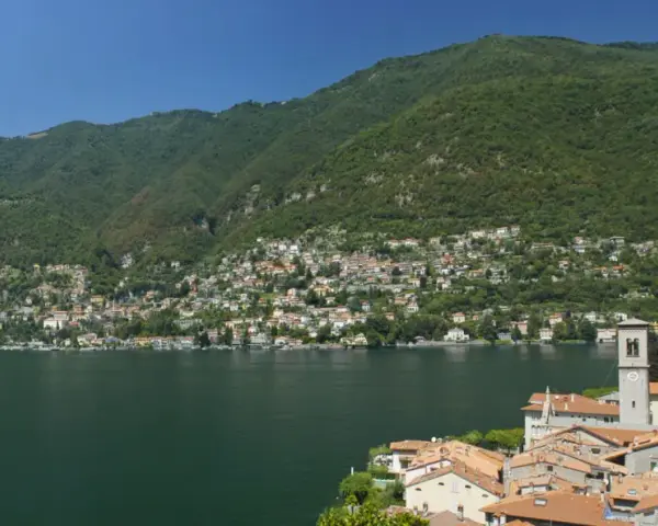 Un'ottima idea per sapere dove andare in montagna in Lombardia in giornata: un borgo pittoresco sul lago, con case colorate e montagne verdi sullo sfondo.