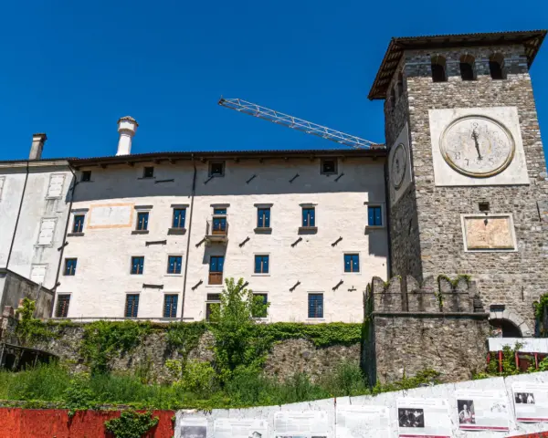 Torre dell'orologio e palazzi storici a Colloredo di Monte Albano, sotto un cielo azzurro.
