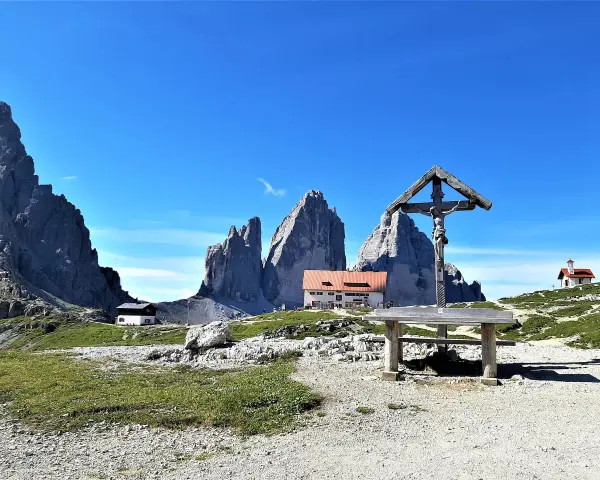 Croce e rifugio al cospetto delle Tre Cime di Lavaredo, un luogo iconico in Val Fiscalina.