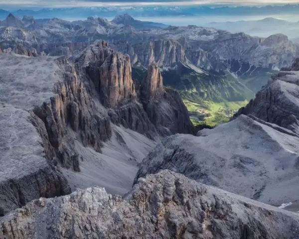 Viste mozzafiato dalle cime rocciose del Piz Boè, con un verde villaggio incastonato tra le valli.