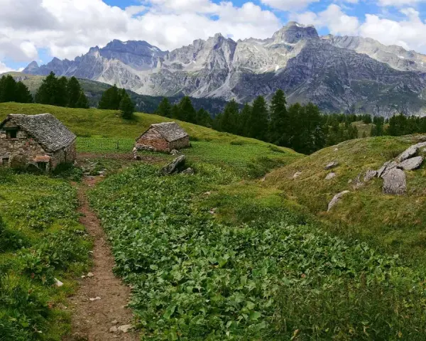 Sentiero per alpe devero trekking tra baite in pietra e montagne maestose.