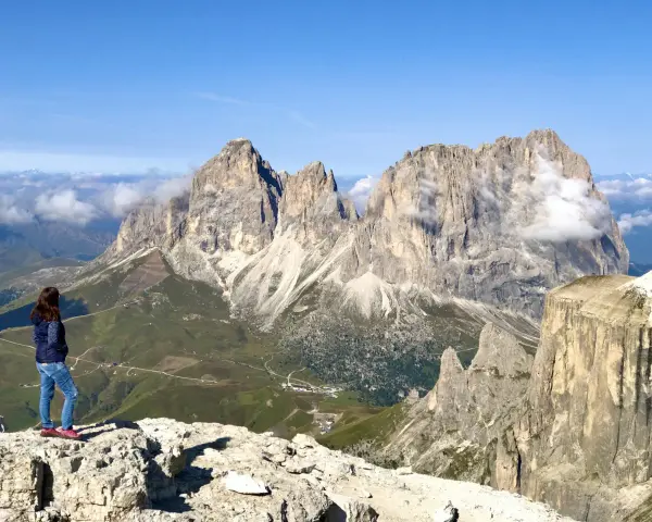 Ragazza ammira la terrazza delle Dolomiti. Per arrivare, prendi la funivia da Canazei.