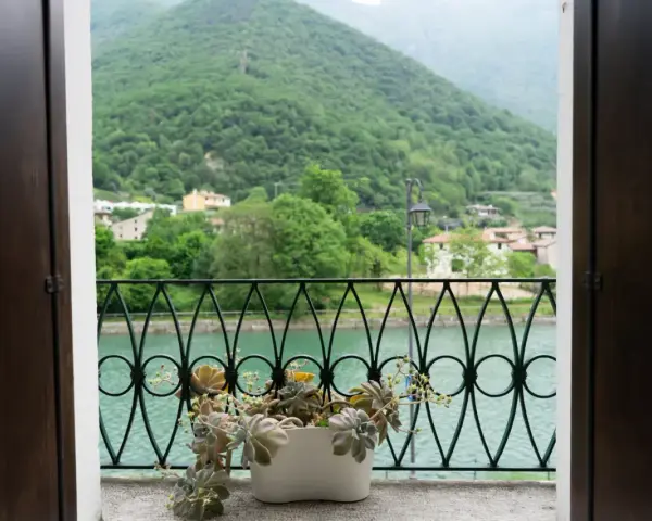 Balcone fiorito con vista sul lago e montagne verdi, un angolo di pace a Cismon del Grappa.