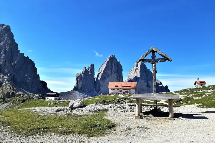 Croce e rifugio al cospetto delle Tre Cime di Lavaredo, un luogo iconico in Val Fiscalina.