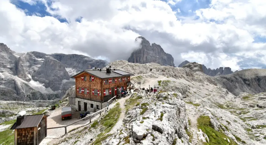 Rifugio Pian di Cengia, un accogliente rifugio alpino tra le maestose Dolomiti, con escursionisti che riposano.