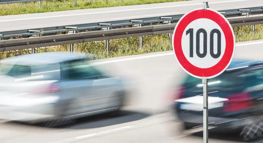 Segnale di limite di velocità 100. Auto in transito, rispettando la tolleranza limite di velocità.