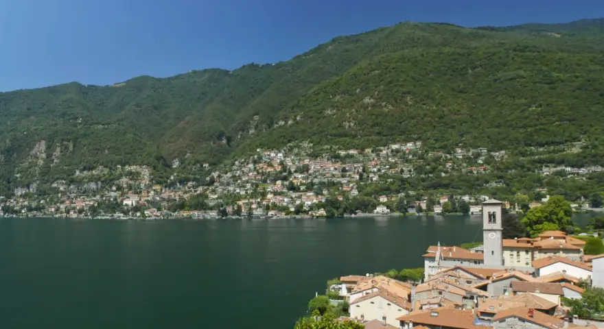 Un'ottima idea per sapere dove andare in montagna in Lombardia in giornata: un borgo pittoresco sul lago, con case colorate e montagne verdi sullo sfondo.